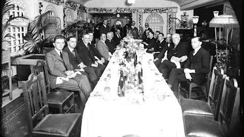 A group of men around a long lavishly set dining table, unknown location, no date. City of Sydney Archives. A-01153307