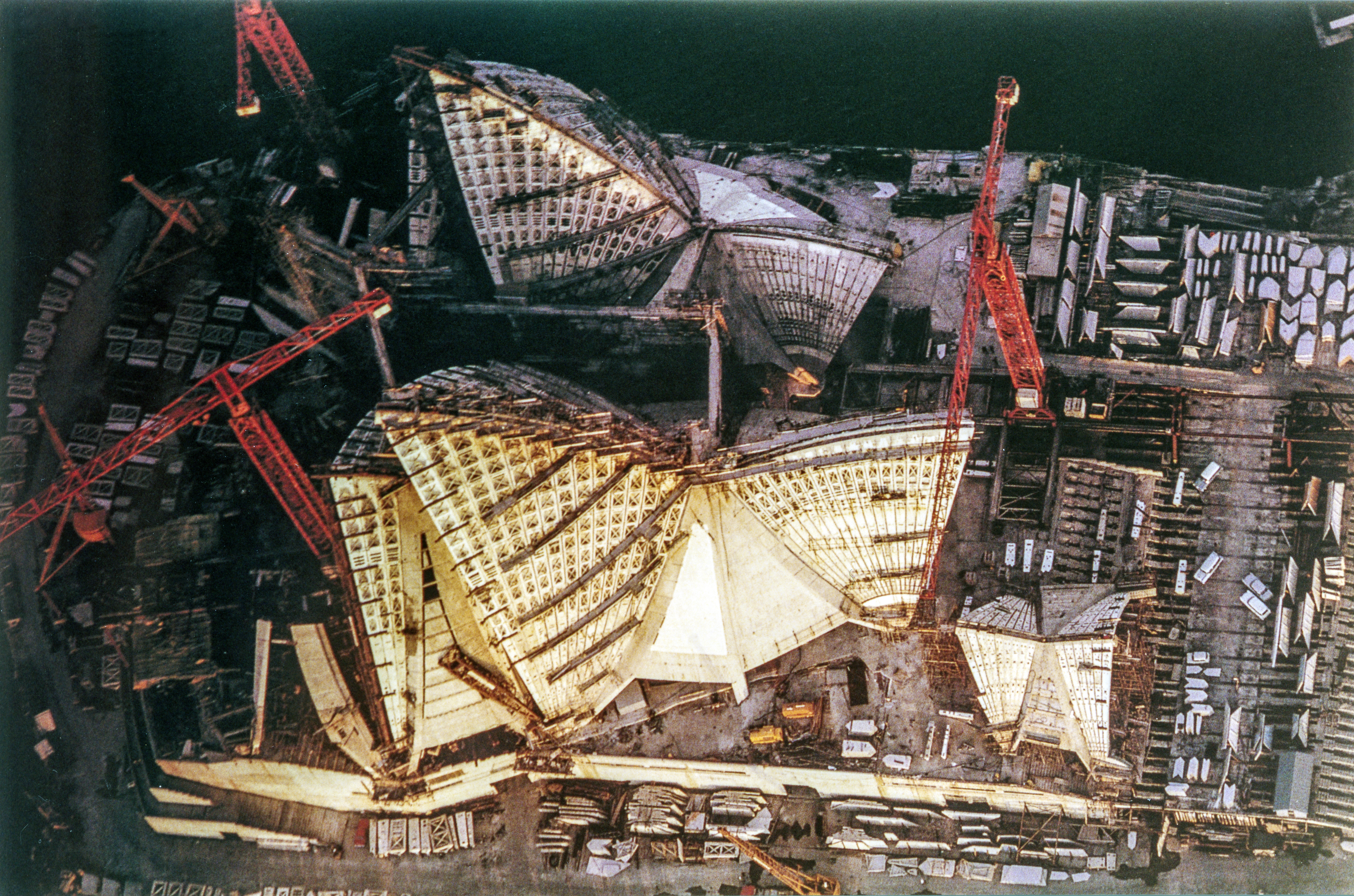 An aerial view of the Opera House construction site. Note the large chevron shaped 'scales' (top right of shot) that make up the intricate patterning of the sails. Photo: Len Stone, City of Sydney Archives, A-00057832