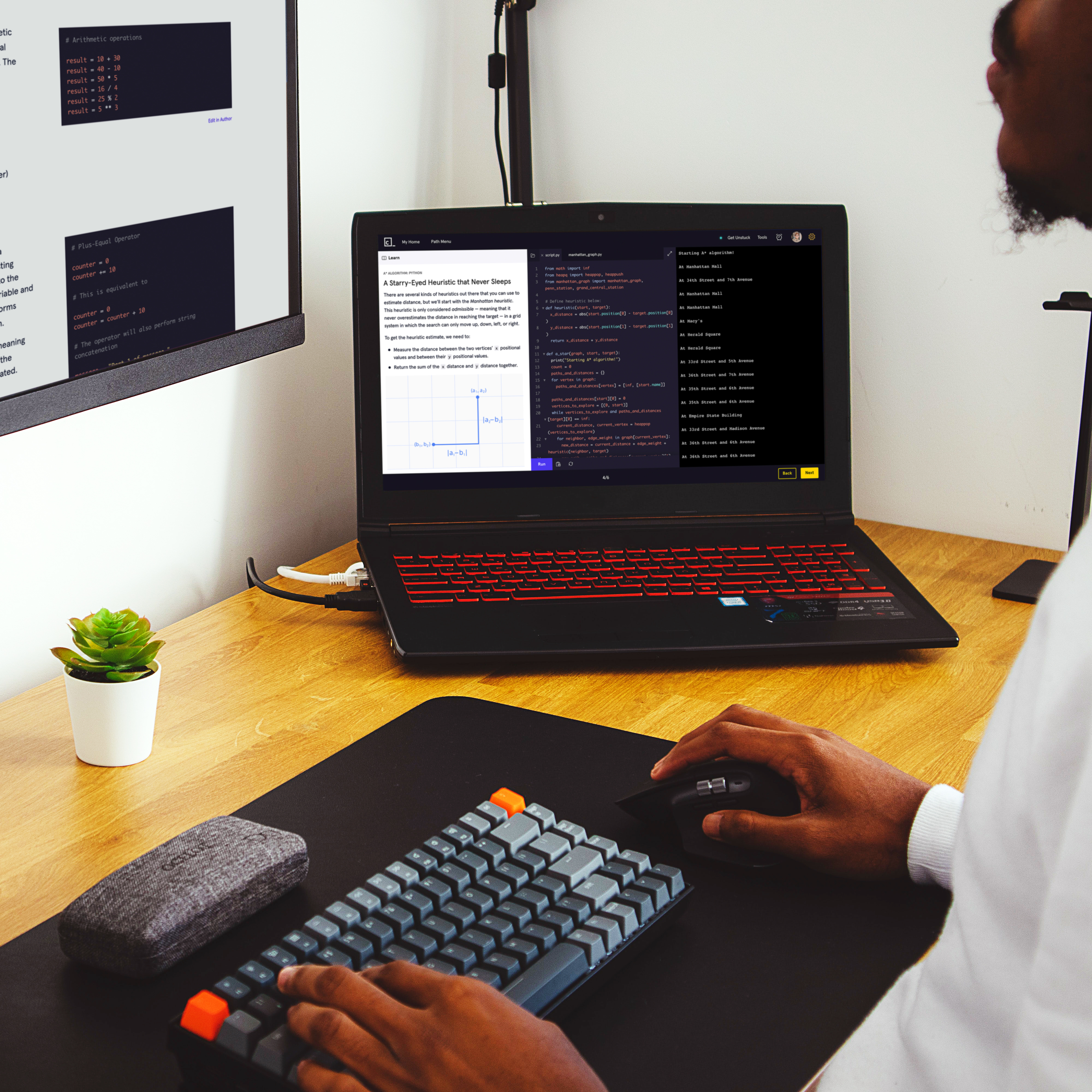 Person coding with two screens and keyboard
