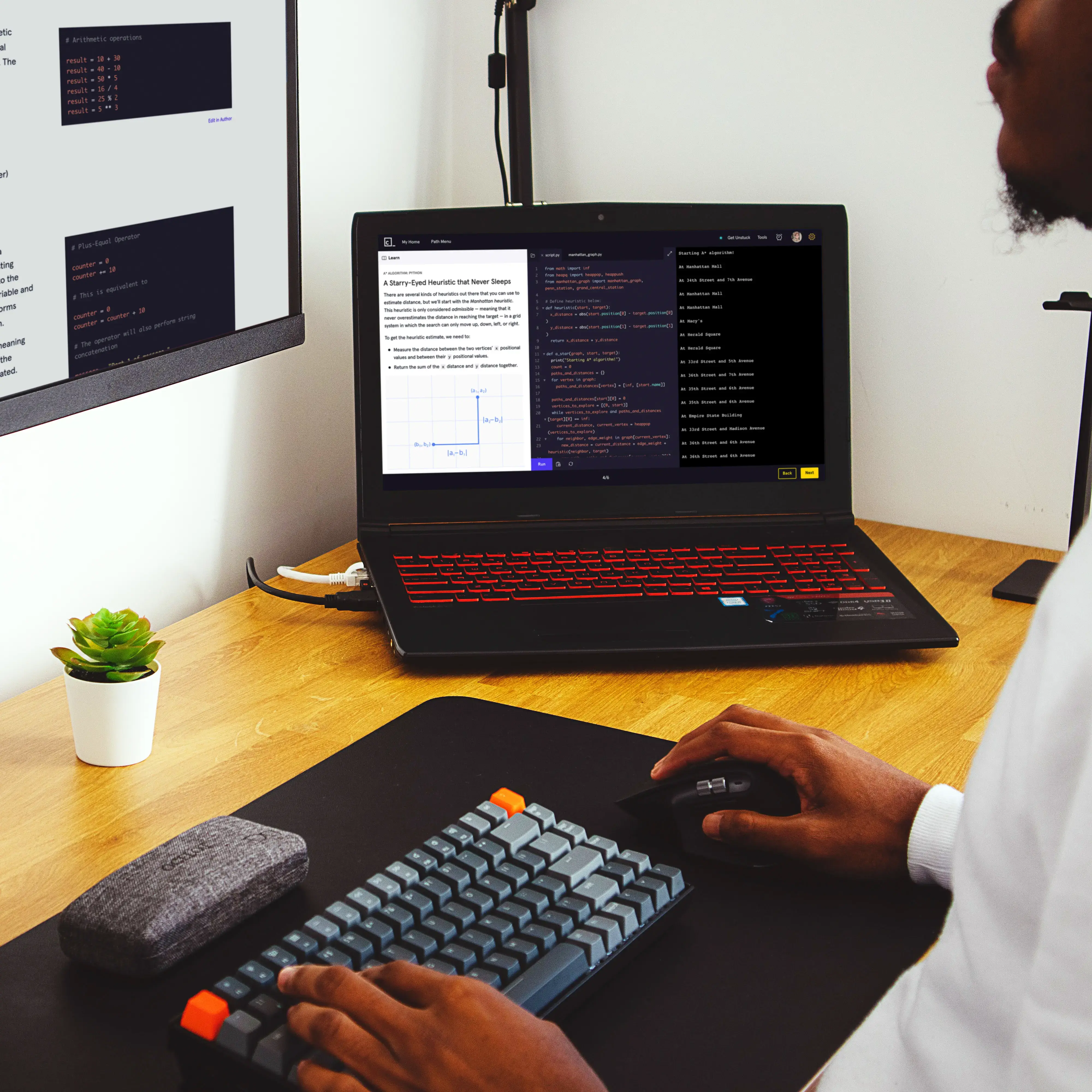 Person coding with two screens and keyboard