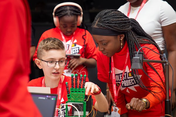 Illustration of two creators working on a robotic hand at a Coolest Projects event