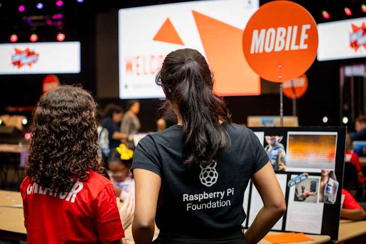 "A judge and participant looking at a mobile app at Coolest Projects UK"