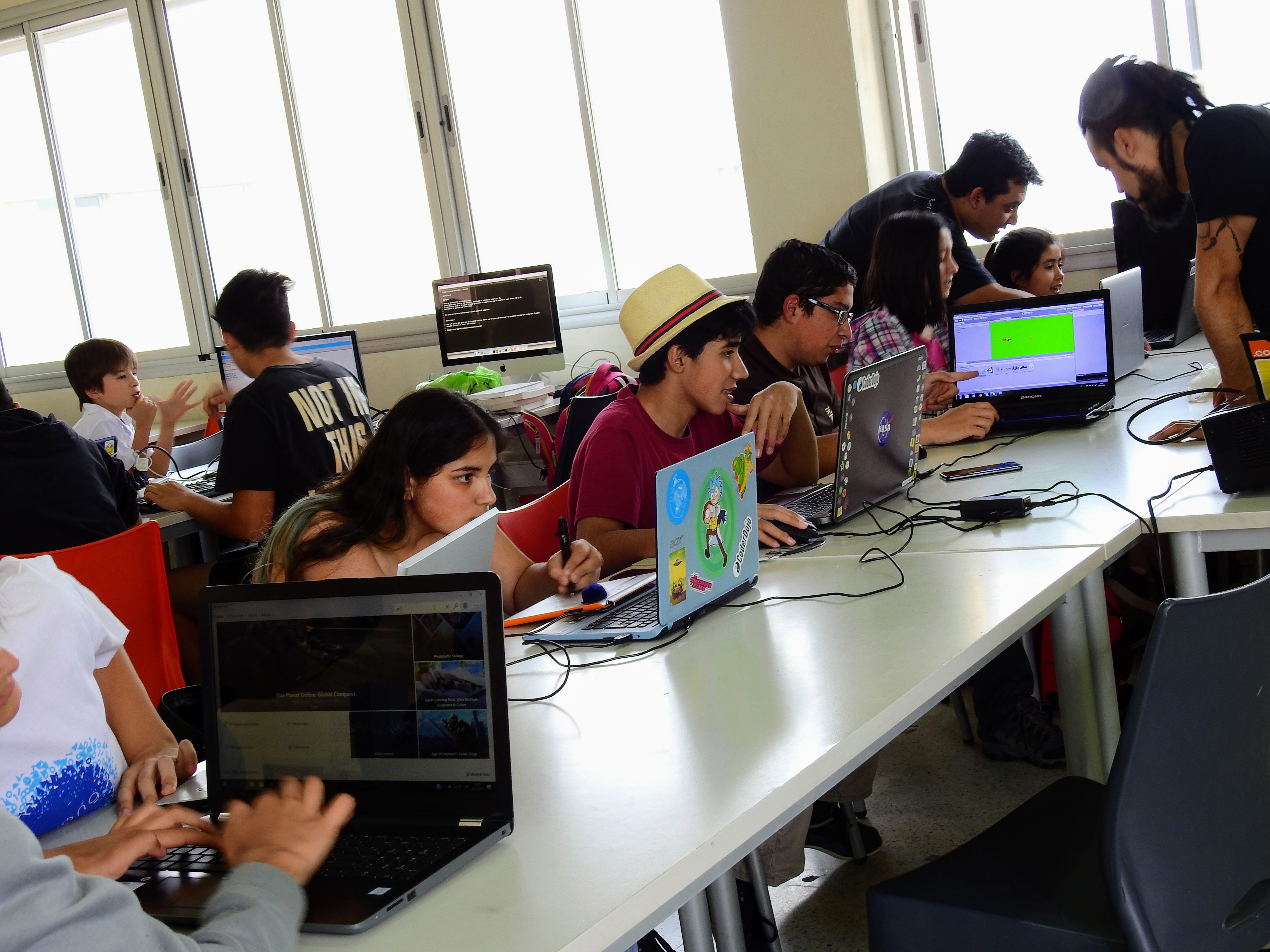 A group of young people look at laptops.