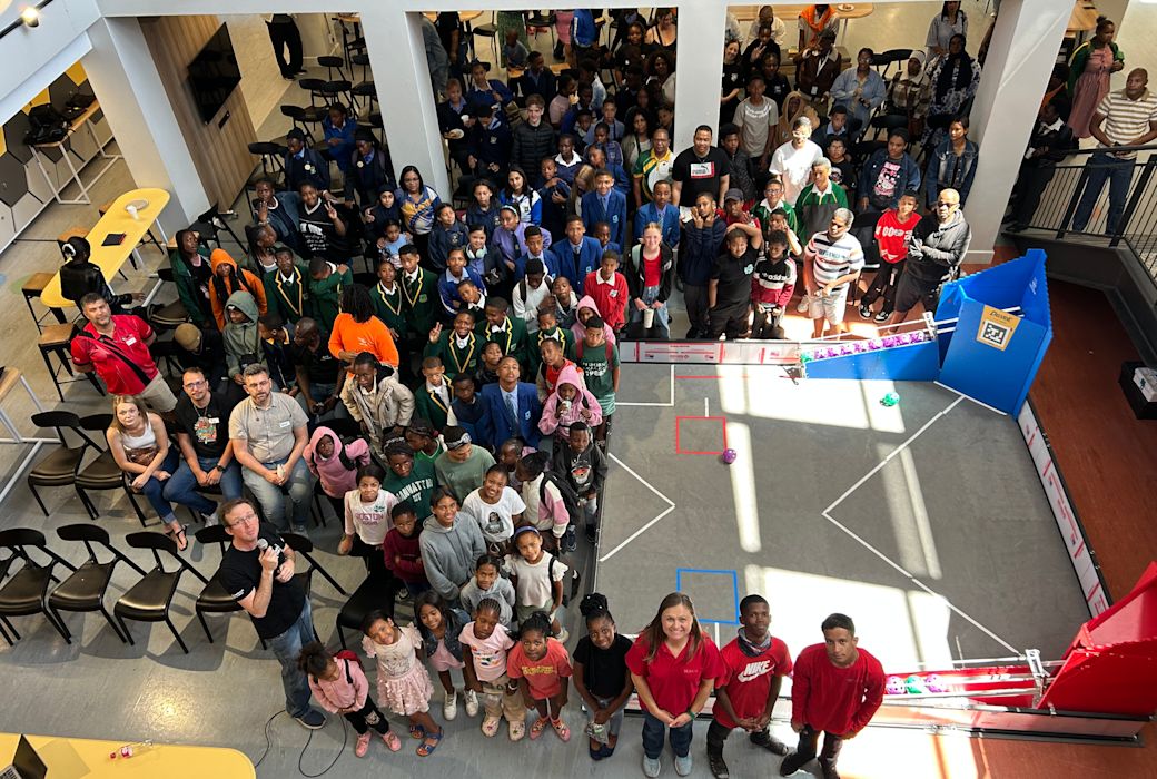 A crowd of young creators and mentors look up at the camera.