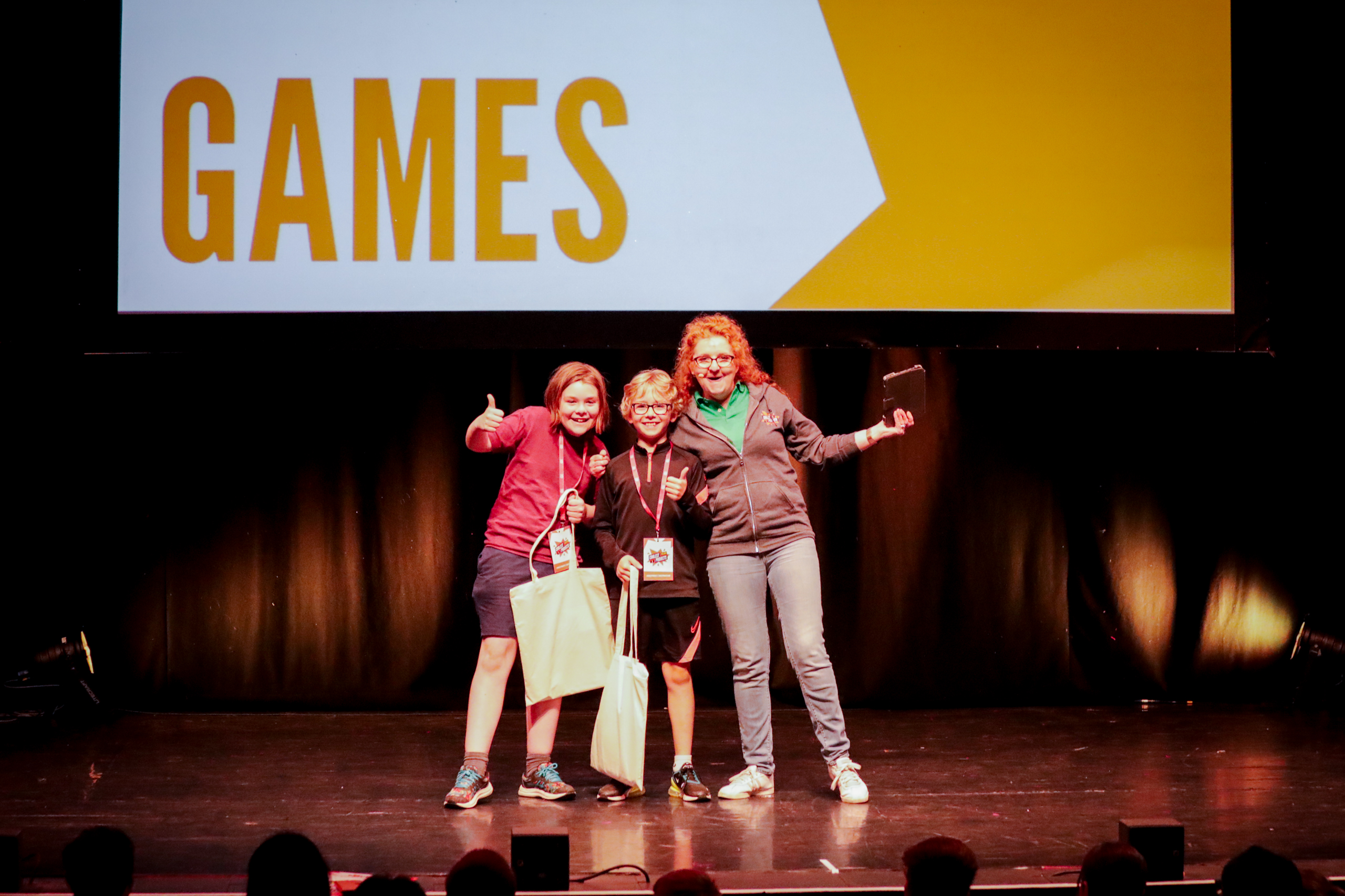 Two young boys collect awards on a stage, from a judge.
