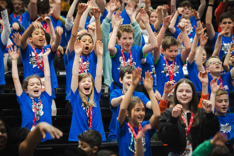 A large group of young people laughing and waving.