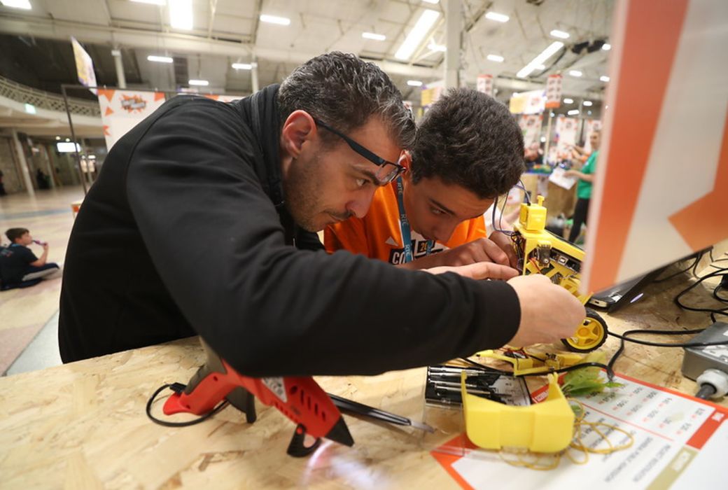A young person and adult mentor build a robotic project