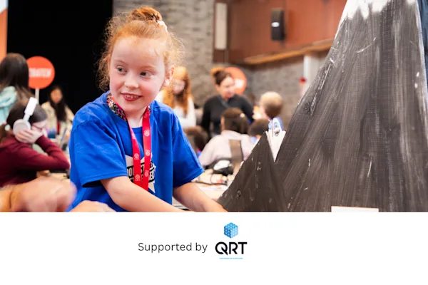 A young girl shows her hardware project at an event.