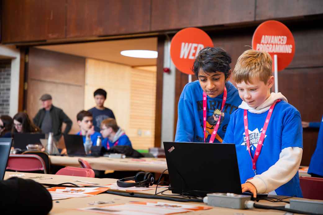 Two participants using a laptop at an in person Coolest Projects event