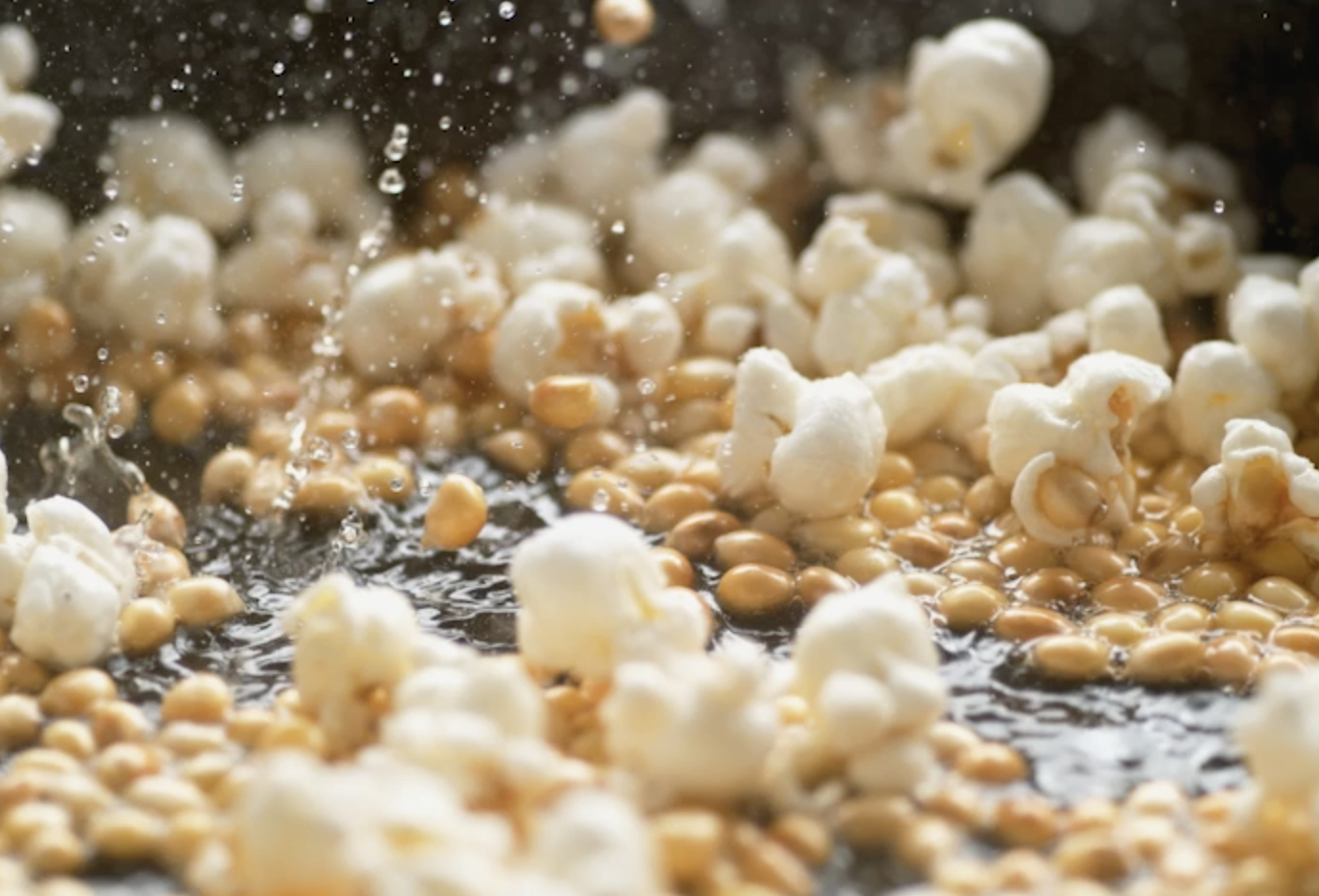 Popcorn popping on heated fry pan. Slow Motion. 
