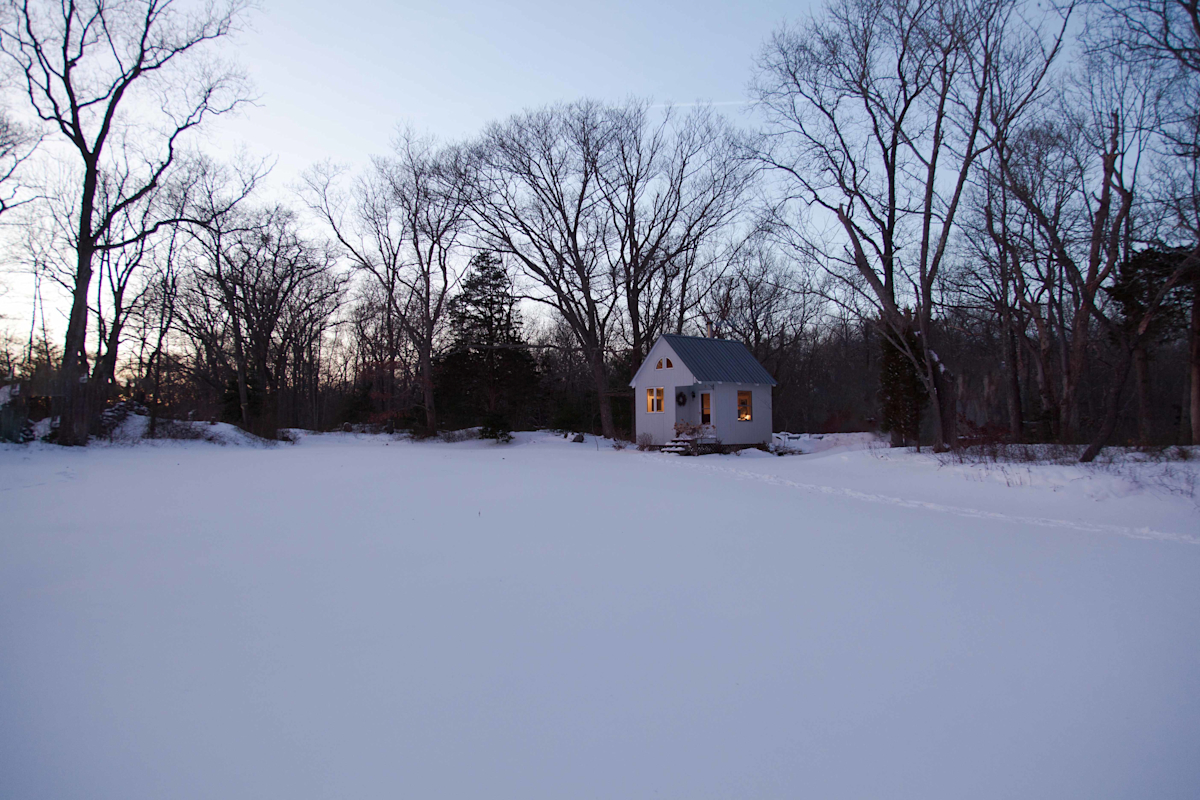 Cohasset Cabin residential interior design by Basicspace. Exterior view during sunset.