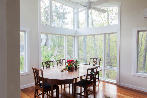 Jerusalem Road House residential interior design by Basicspace. View of the dining room with an open view into the outdoors. Vaulted ceilings with floor to ceiling custom glass.