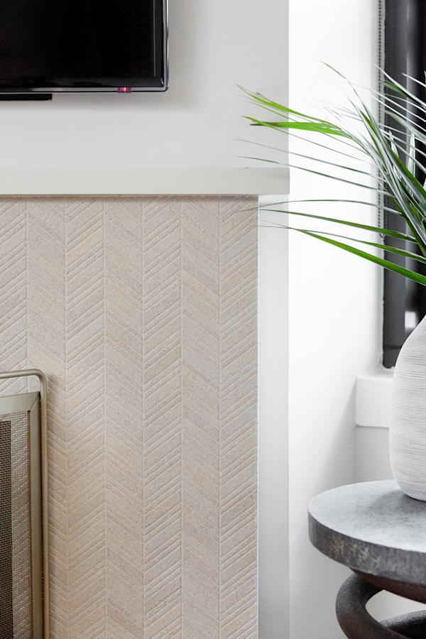 Hell's Kitchen Loft residential interior design by Basicspace. Detail of fireplace tile in front of windows. Concrete side table and plant.