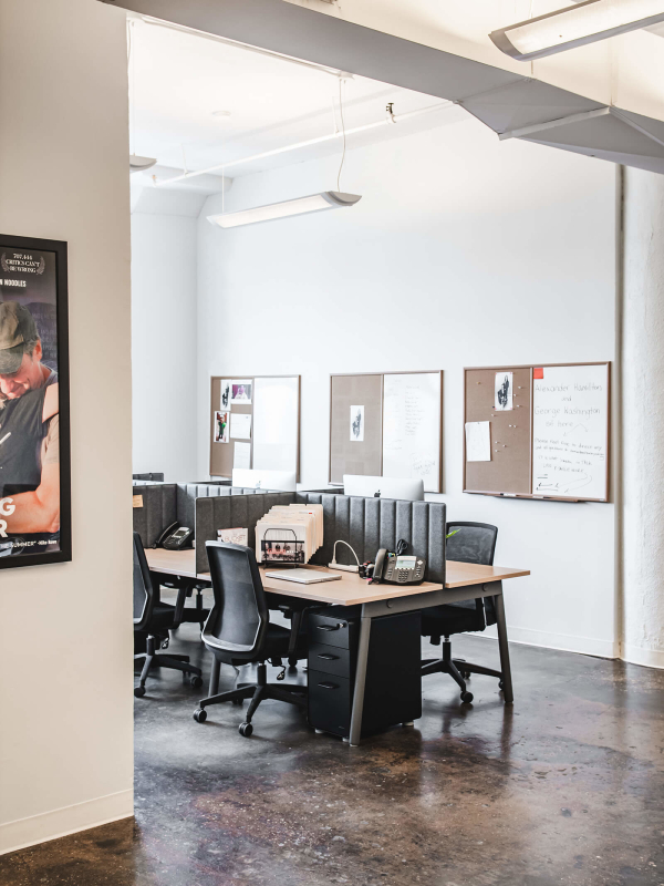 Hudson Media office interior design renovation by Basicspace. View towards employee collective workstation displaying use of low felt partitions.