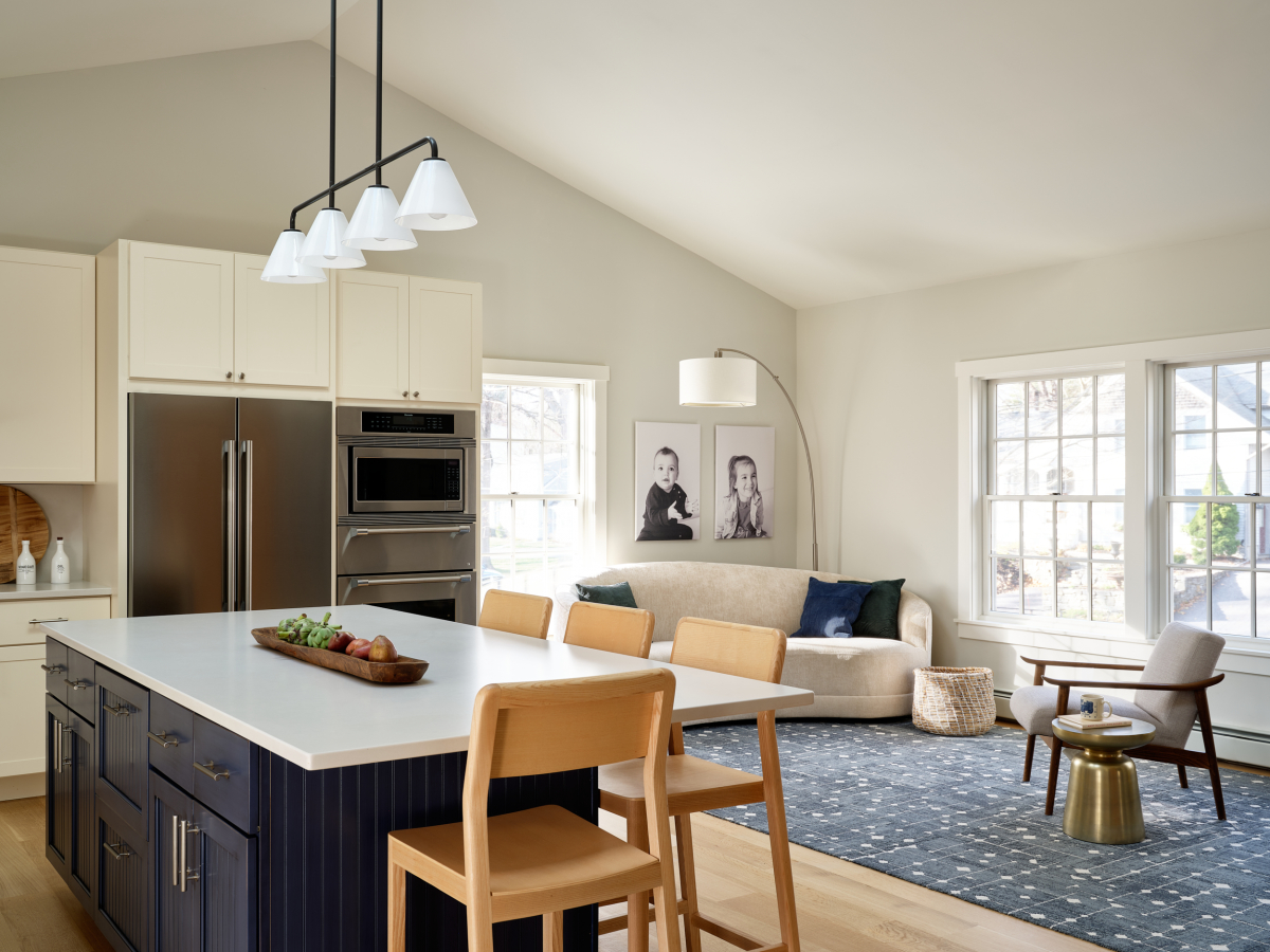 The home features an open and airy kitchen and living room. A modern pendant hangs from the vaulted ceiling, directly above the kitchen island.