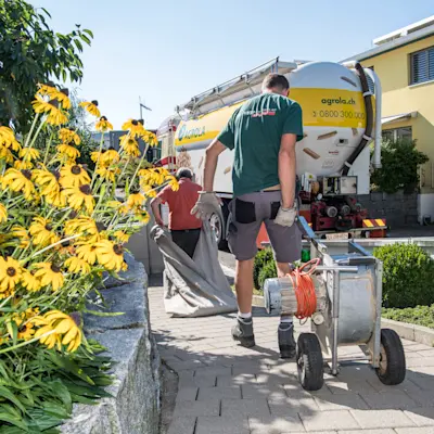 Des hommes transportent des outils pour le nettoyage du local de stockage des pellets de bois