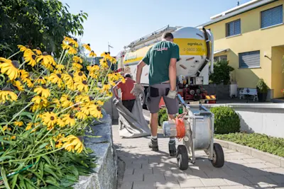 Des hommes transportent des outils pour le nettoyage du local de stockage des pellets de bois