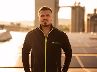 Collaborateur AGROLA sur le toit devant l'installation solaire