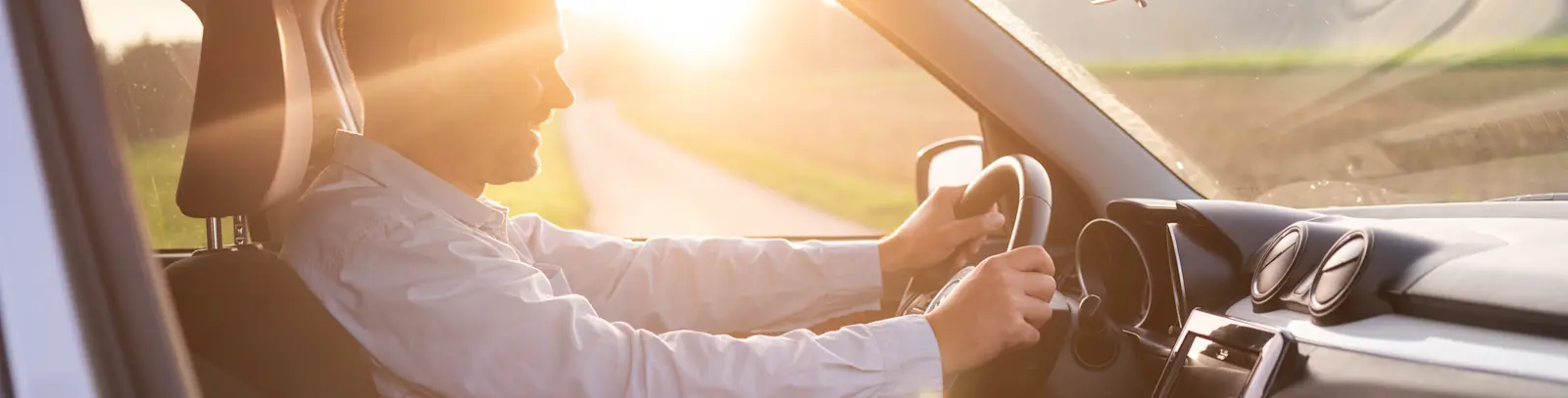 Mobilität - Mann am Steuer bei Sonnenaufgang
