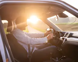 Mobilität - Mann am Steuer bei Sonnenaufgang