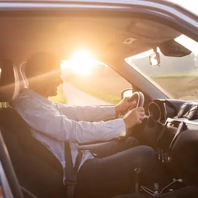 Mobilität - Mann am Steuer bei Sonnenaufgang