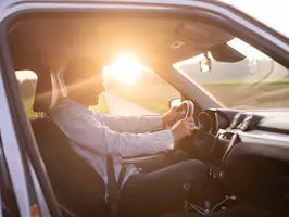 Mobilität - Mann am Steuer bei Sonnenaufgang