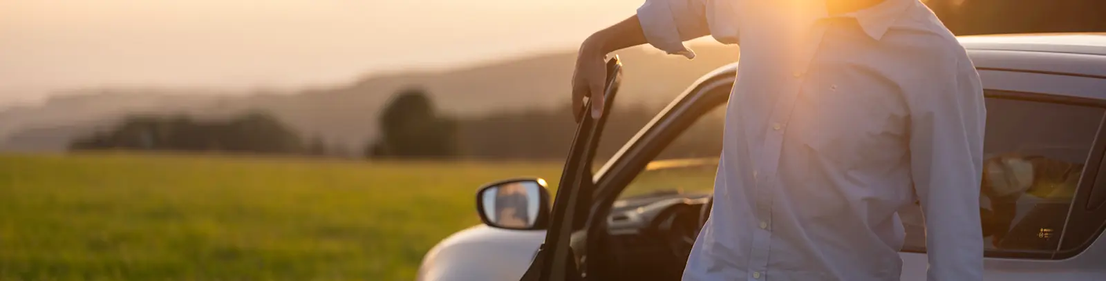 Bild Mobilität - Mann steigt aus Auto aus bei Sonnenaufgang
