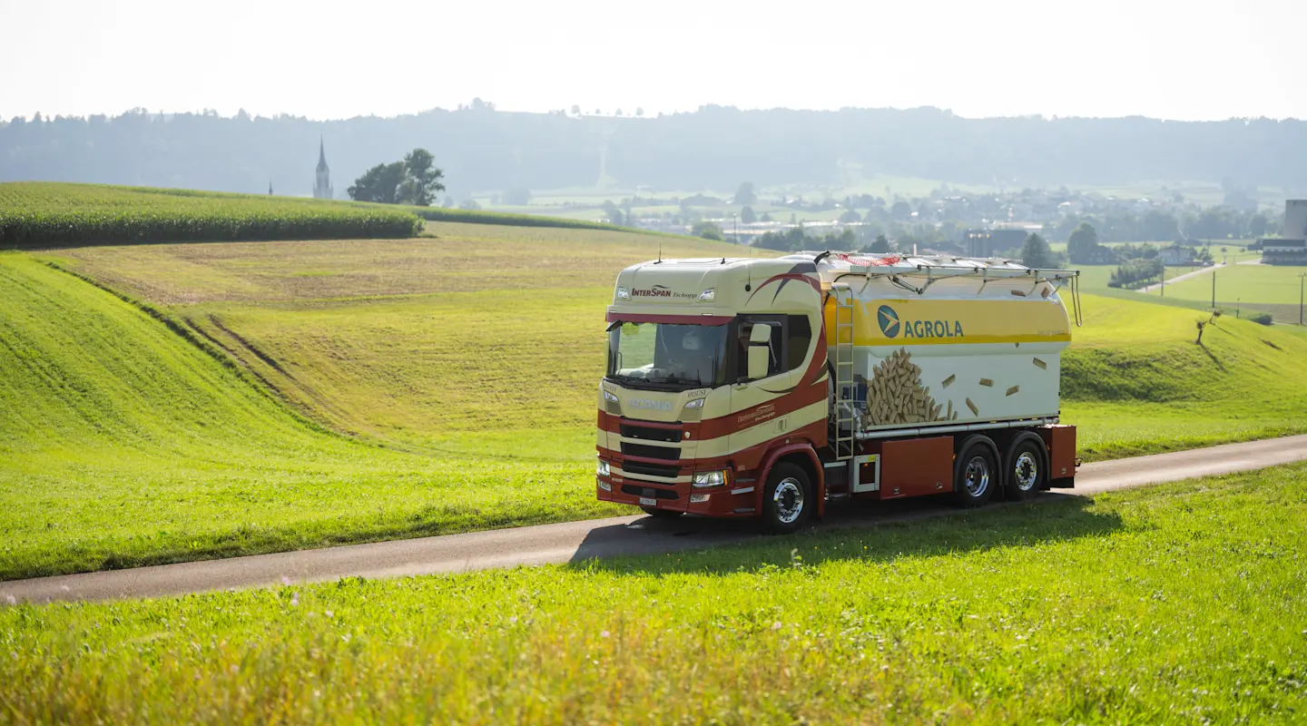 Le camion de pellets de bois AGROLA en route entre prairies et champs