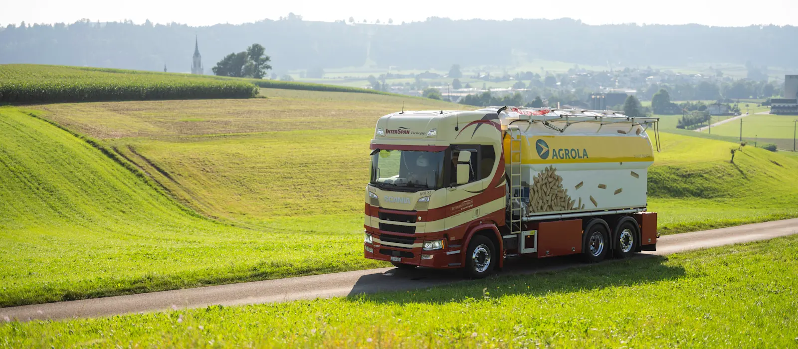 AGROLA Holzpellets-LKW unterwegs zwischen Wiesen und Feldern