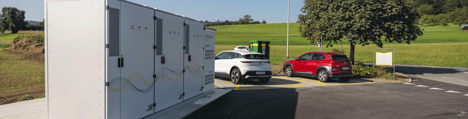 Microgrid AGROLA et station de recharge rapide AGROLA avec deux voitures en recharge sur le site de LANDI Sursee à Oberkirch