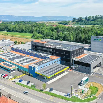 Ansicht des AGROLA MicroGrid der LANDI Sursee in Oberkirch. Links AGROLA Dachband erkennbar. Frtaonl im Zentrum Schnellladestation von AGROLA, rechts mit weissem Kasten dem MicroGrid. © Daniel Ammann, all rights reserved