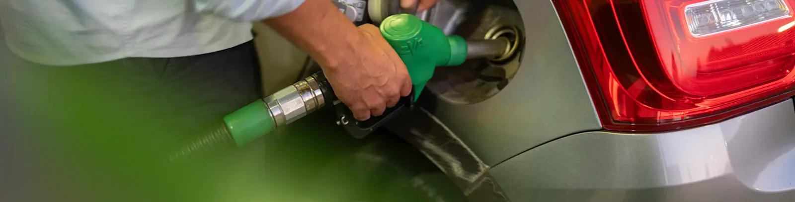 Vue détaillée d'un homme faisant le plein à la station-service AGROLA