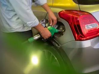 Vue détaillée d'un homme faisant le plein à la station-service AGROLA