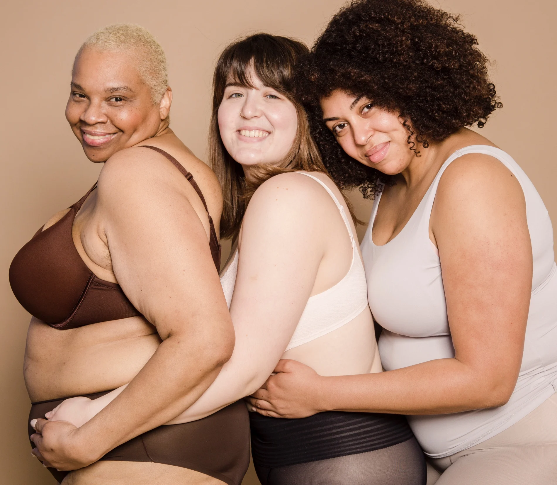 Drei übergewichtige Frauen lachen in die Kamera