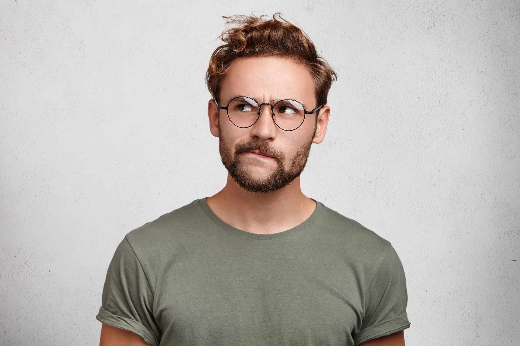 Homme portant des lunettes pensant aux soins postopératoires après sa greffe de cheveux