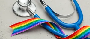 Sex reassignment surgery image with stethoscope and LGBT rainbow ribbon.