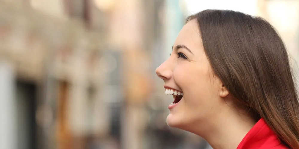 Lächelnde Frau informiert sich über die besten Länder für Nasenkorrekturen