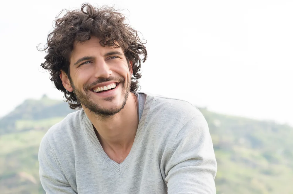 Man with great teeth smiling in a countryside setting