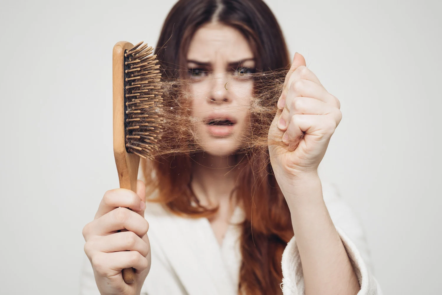 Femme qui perd ses cheveux sur une brosse à cheveux