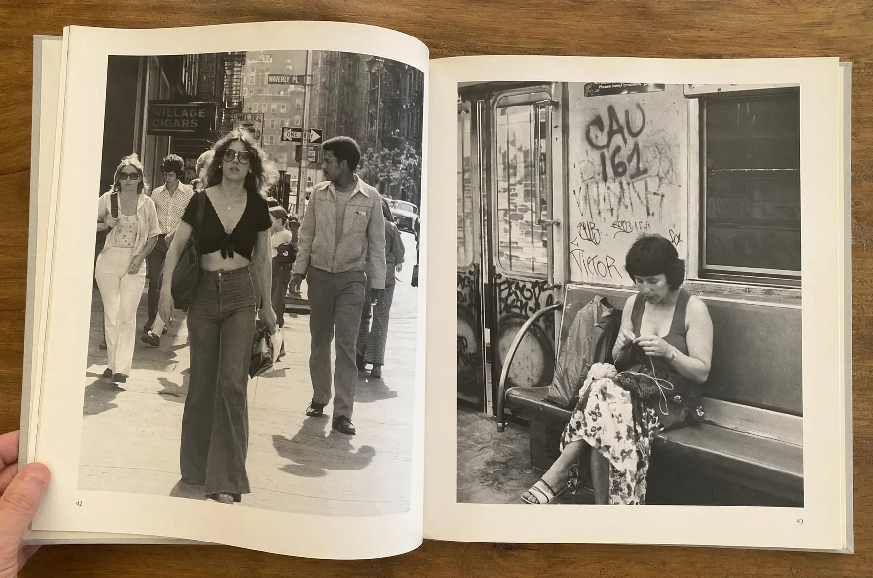 Generated with ChatGPT Images 2.0, this black-and-white photo book spread shows two candid street-style images: pedestrians walking through a city sidewalk on the left and a person knitting while seated in a graffiti-marked subway car on the right, evoking documentary 35mm photography.