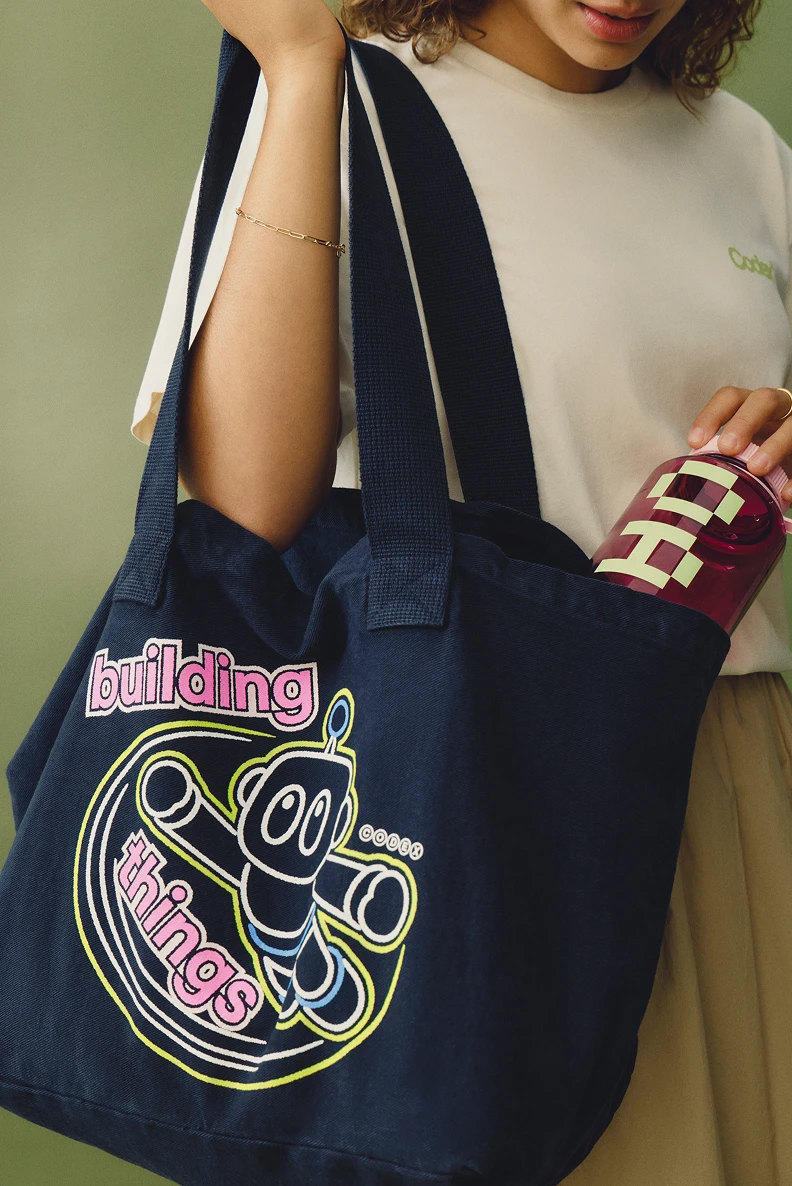 Person carrying a navy Building Things tote bag