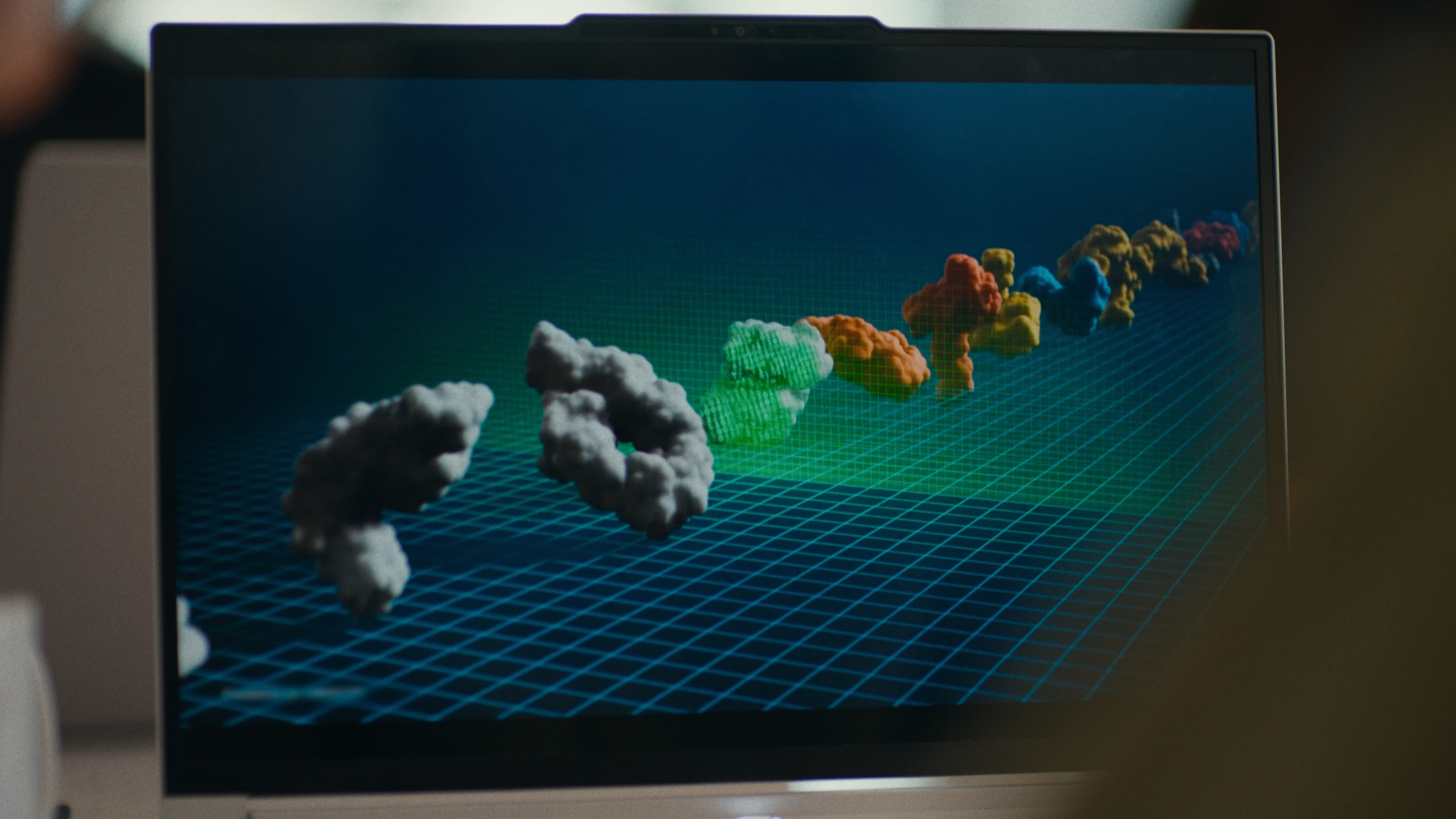 A laptop screen showing molecular structures on a gridded visualization.