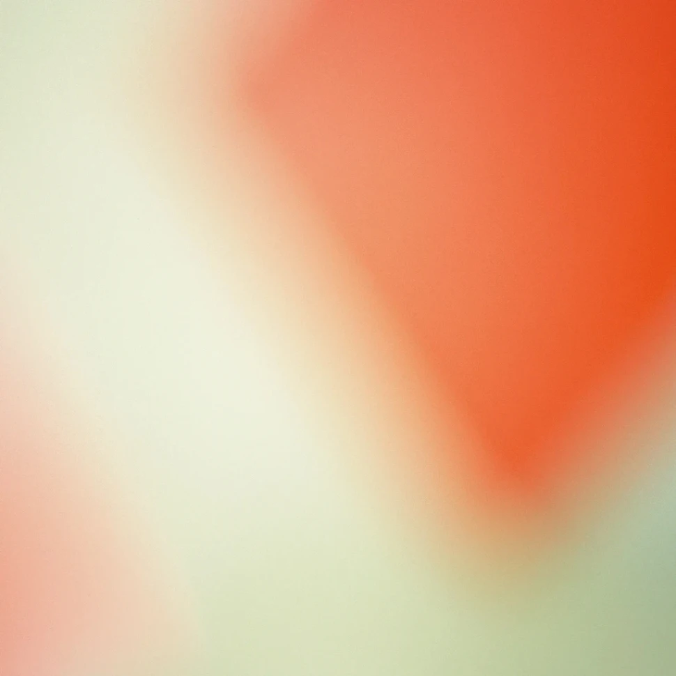 This is an abstract image featuring a soft focus blend of colors with a dominant orange triangle fading into a creamy white background.