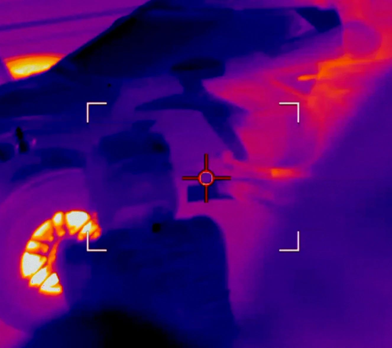 Thermal view of an IndyCar and pit crew during a pit stop.