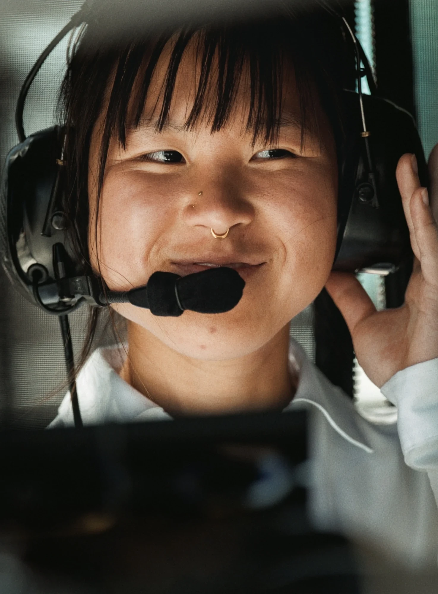A smiling researcher wears a headset with a microphone.