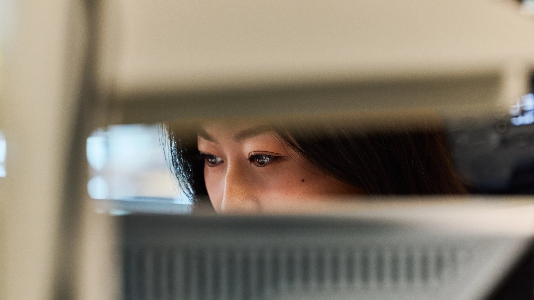 A researcher reviewing work on a laptop in a lab workspace.