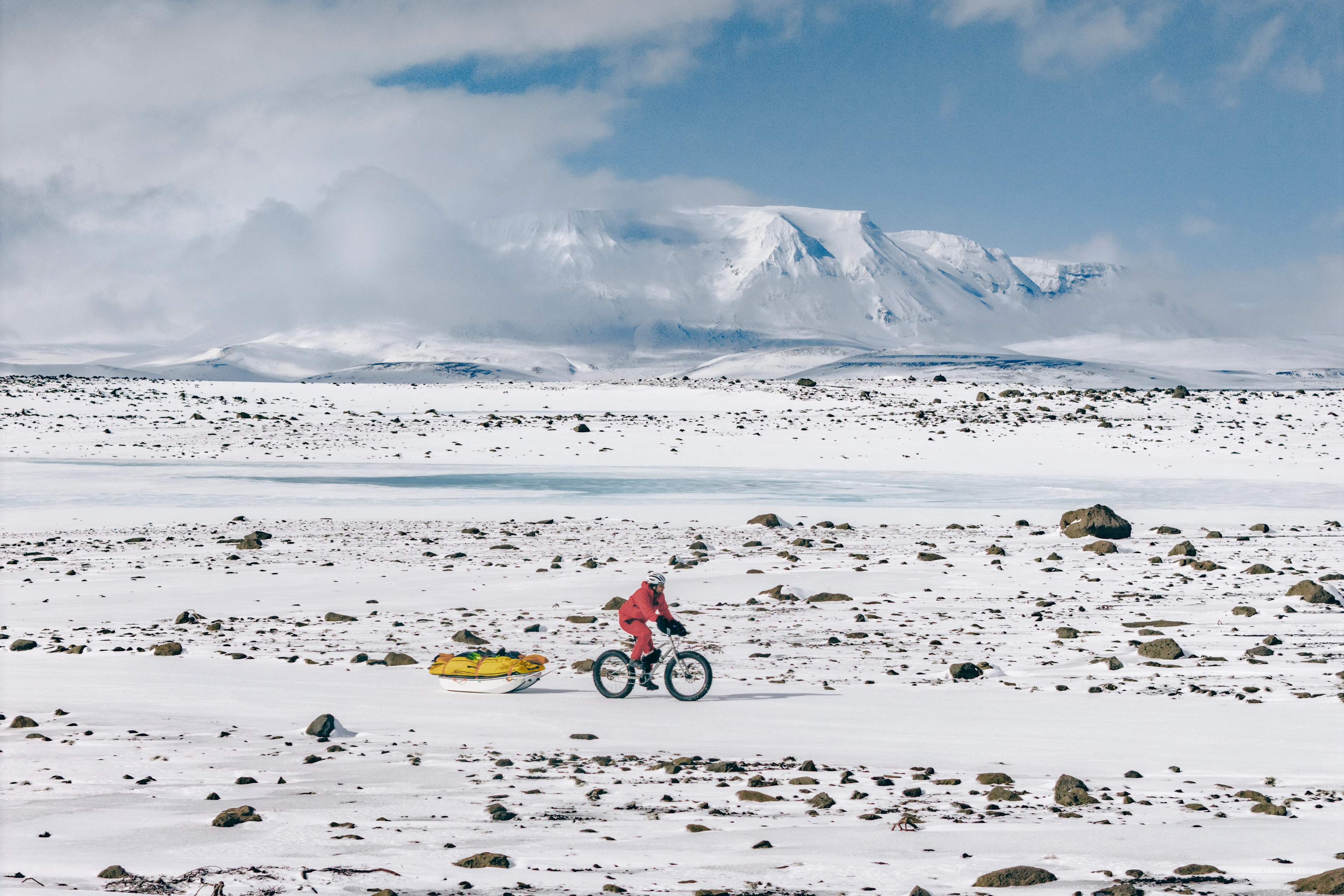 James tows gear and supplies by bike across snowy terrain in Iceland.