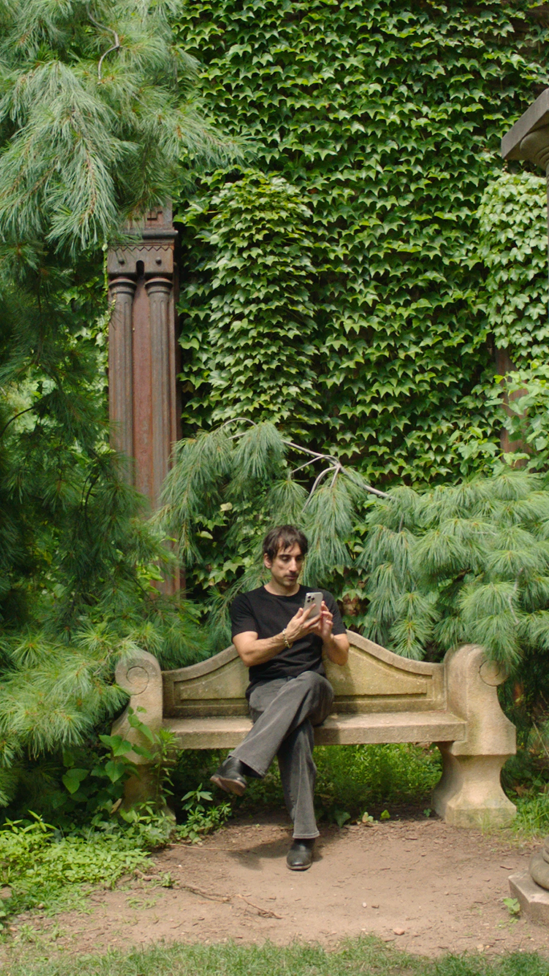 GPT-5 user Pietro sits in a lush green garden while using ChatGPT on his phone.