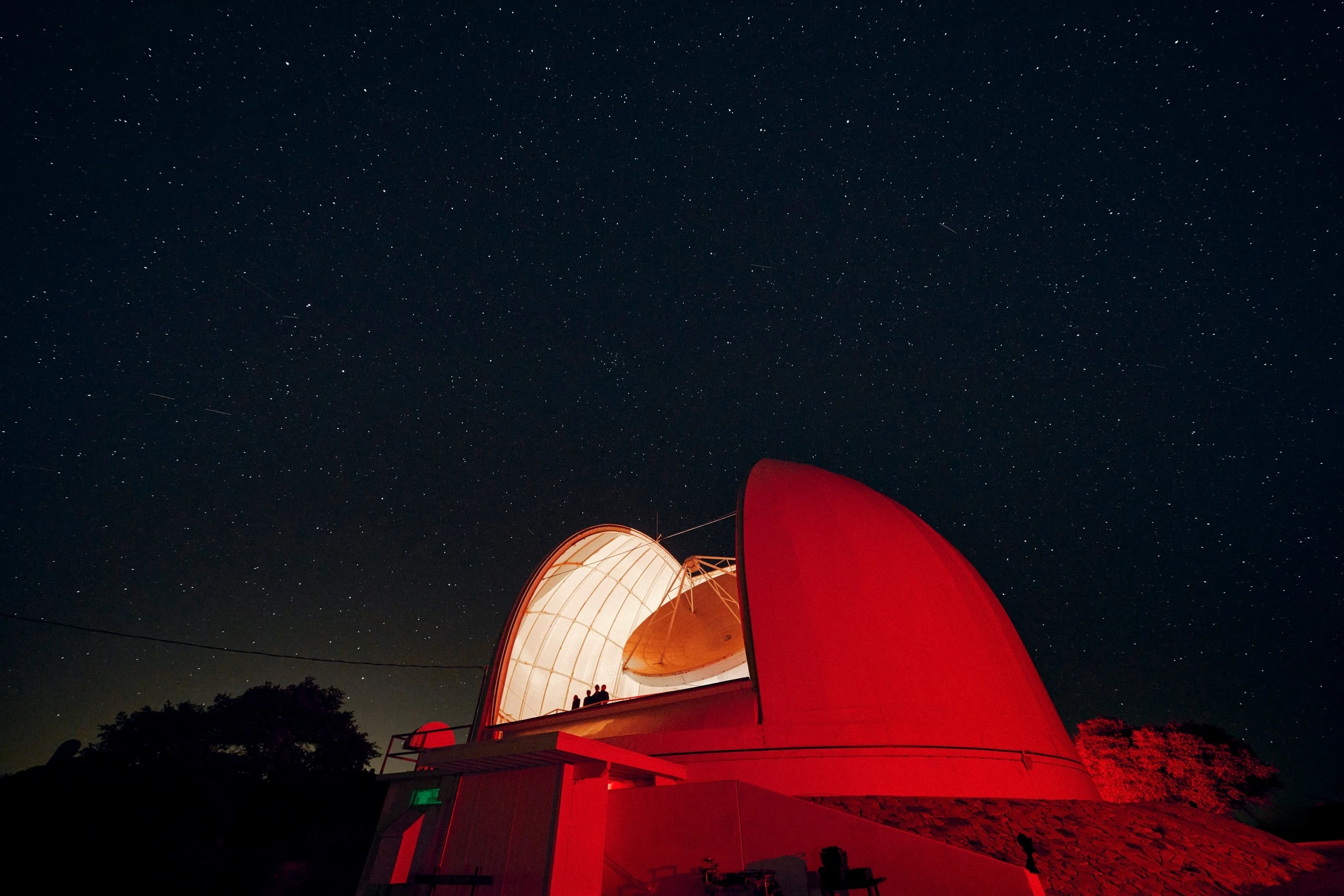 A radio telescope under a starry sky at Kitt Peak National Observatory.