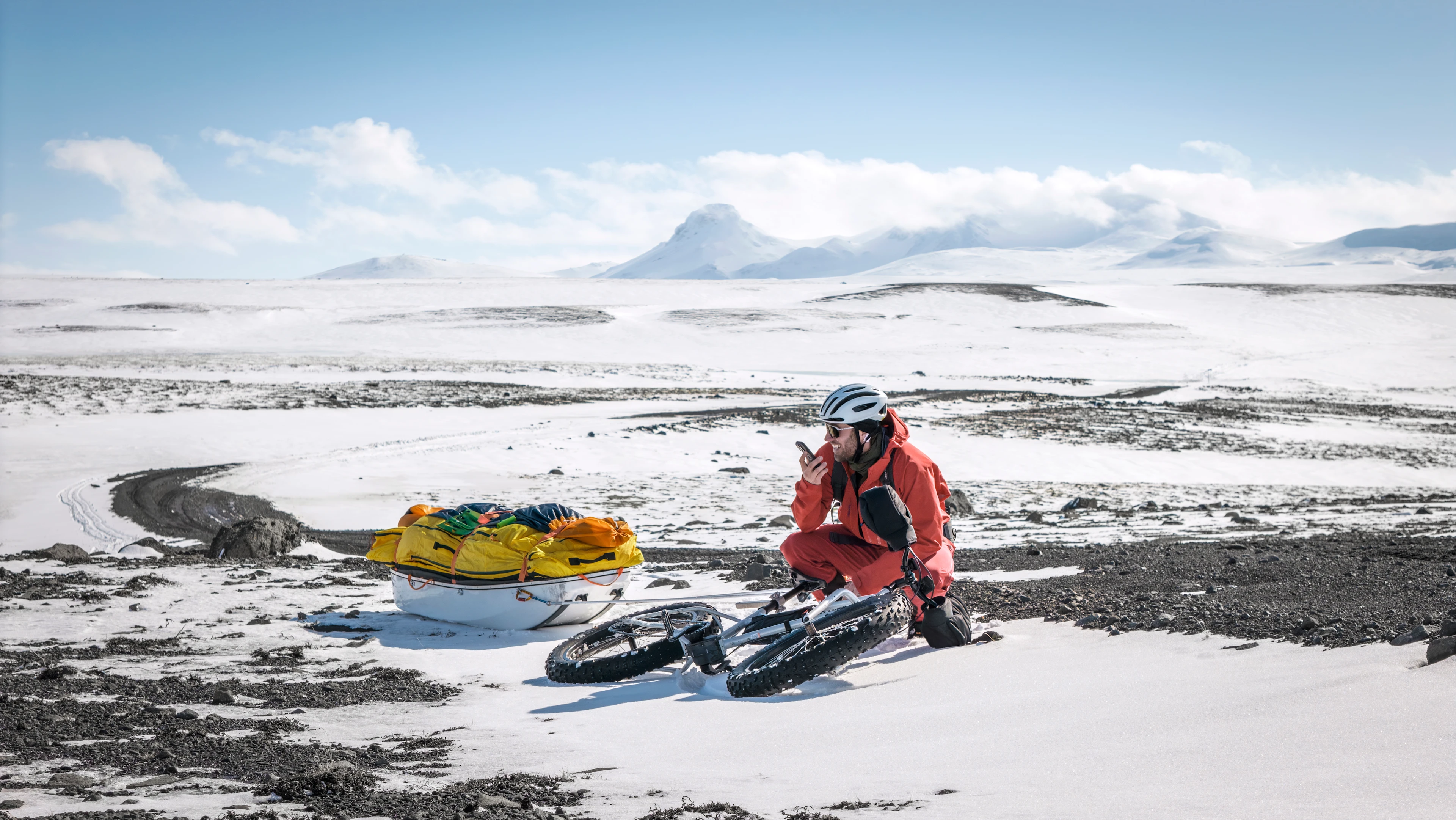 James uses a phone beside his bike while logging training notes during a snowy ride.